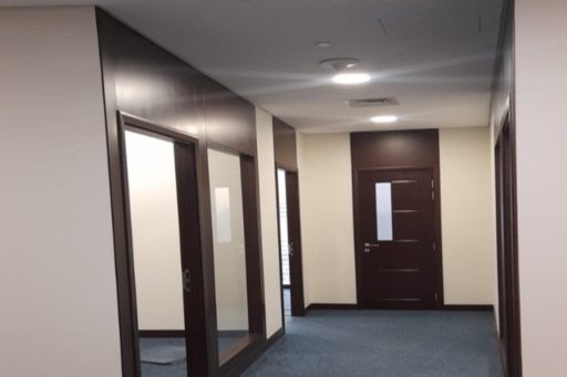 Refurbished office corridor with timber doors and glazed partitions at Kanoo Tower, Bahrain