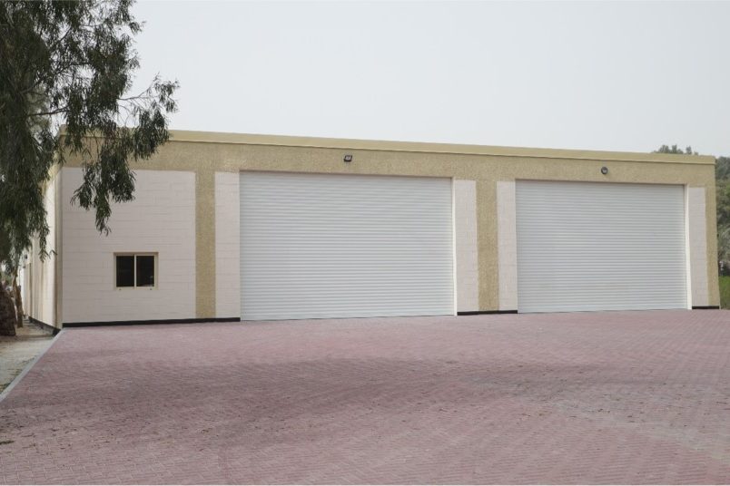 Completed warehouse with roller shutter doors and block-paved yard in Bahrain